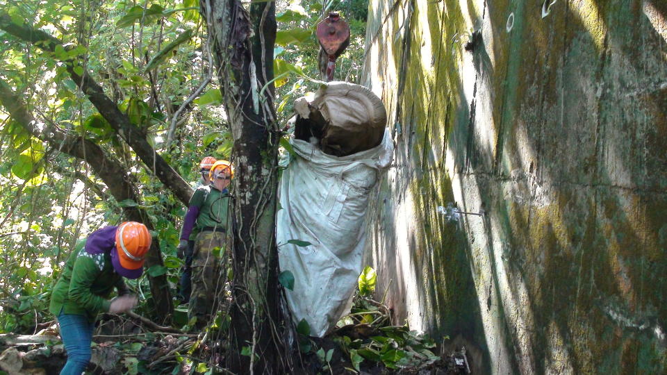 嘉義縣梅山鄉公所在圳南村發現大量「垃圾瀑布」，近日號召150名村民進行2天清除，並從中吊出大型廢棄傢俱。（圖／嘉義縣政府提供）              