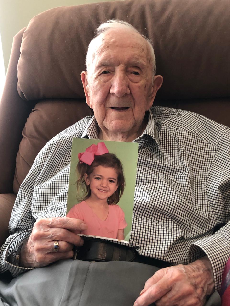 Bob Early, who turned 100 in June, holds a photo of his great granddaughter, Ellen.
