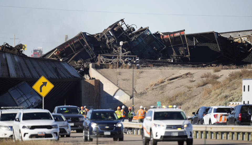 Workers toil to clear cars that derailed in an accident over Interstate 25 northbound, Monday, Oct. 16, 2023, north of Pueblo, Colo. (AP Photo/David Zalubowski)