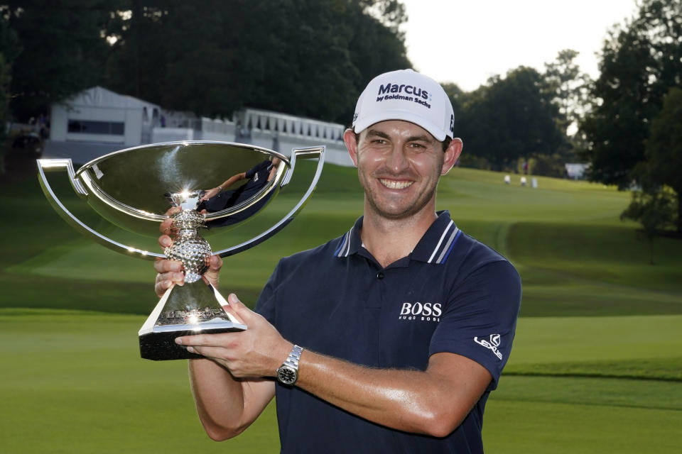 Patrick Cantlay poses with the trophy after winning the Tour Championship golf tournament and the FedEx Cup at East Lake Golf Club, Sunday, Sept. 5, 2021, in Atlanta. (AP Photo/Brynn Anderson)