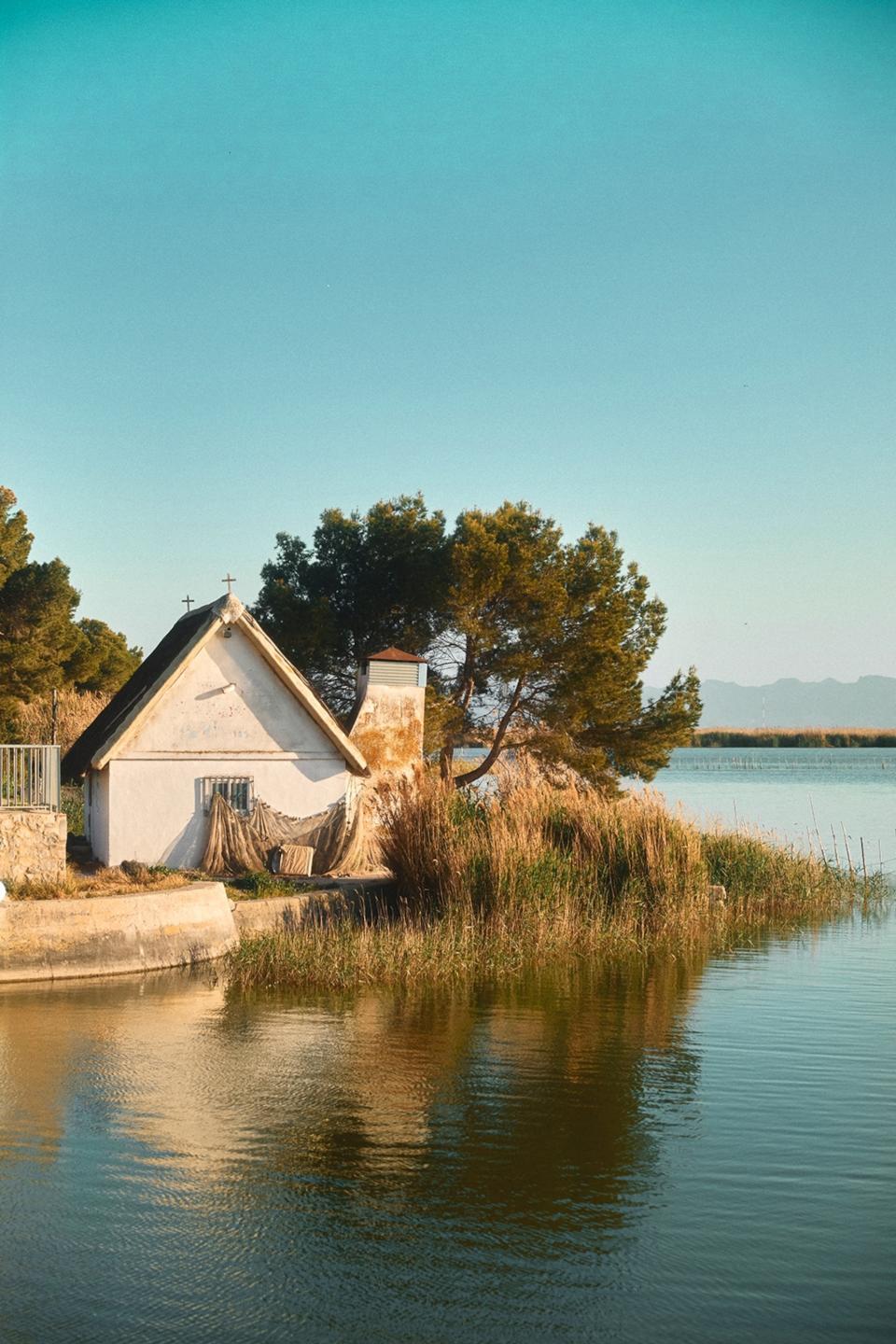 Cottage next to a lake and grassland