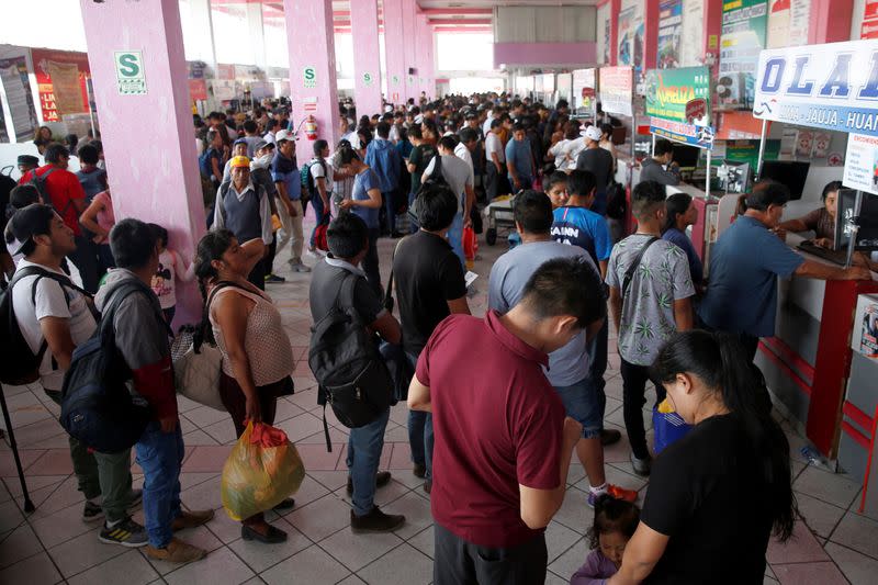 People queue to buy tickets at a bus station after Peru's government deployed military personnel to block major roads, as the country rolled out a 15-day state of emergency to slow the spread of coronavirus disease (COVID-19), in Lima