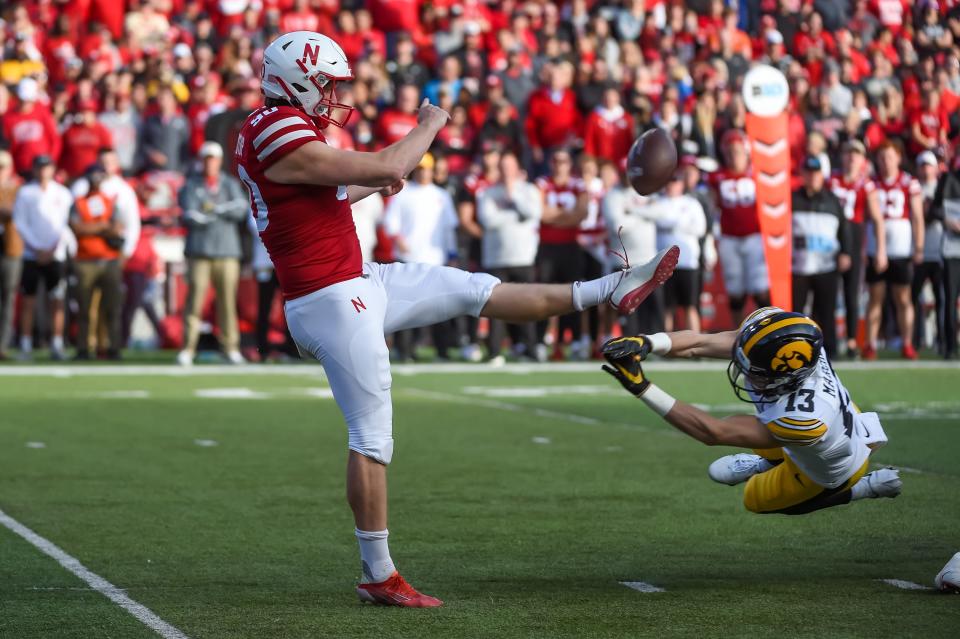 Iowa defensive back Henry Marchese, right, blocks the punt of Nebraska's William Przystup resulting in a touchdown in the second half, Friday, Nov. 26, 2021, at Memorial Stadium, in Lincoln, Neb.