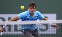 Milos Raonic, of Canada, returns a hit to Alexandr Dolgopolov, of Ukraine, during a quarterfinal match at the BNP Paribas Open tennis tournament on Thursday, March 13, 2014, in Indian Wells, Calif. (AP Photo/Mark J. Terrill)