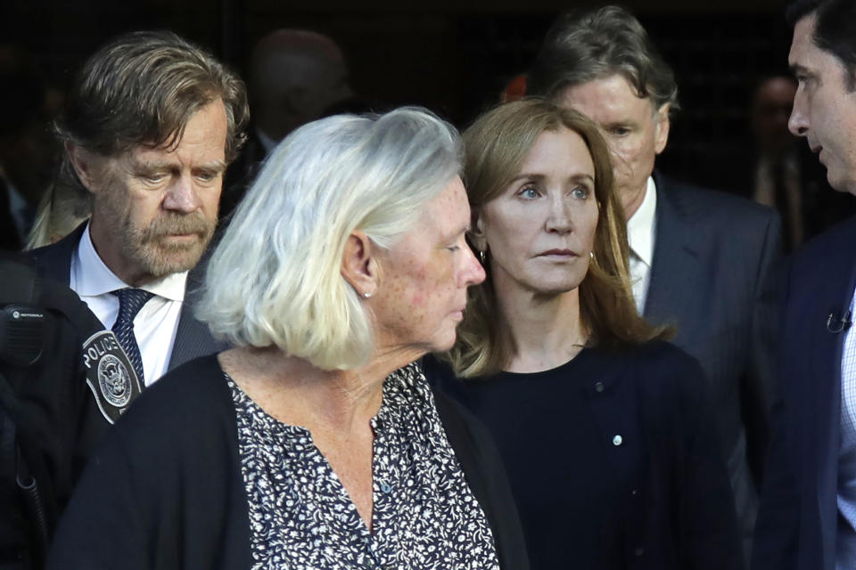 Felicity Huffman, right, leaves federal court with her husband William H. Macy, far left, after her sentencing in a nationwide college admissions bribery scandal, Friday, Sept. 13, 2019, in Boston. (AP Photo/Elise Amendola)