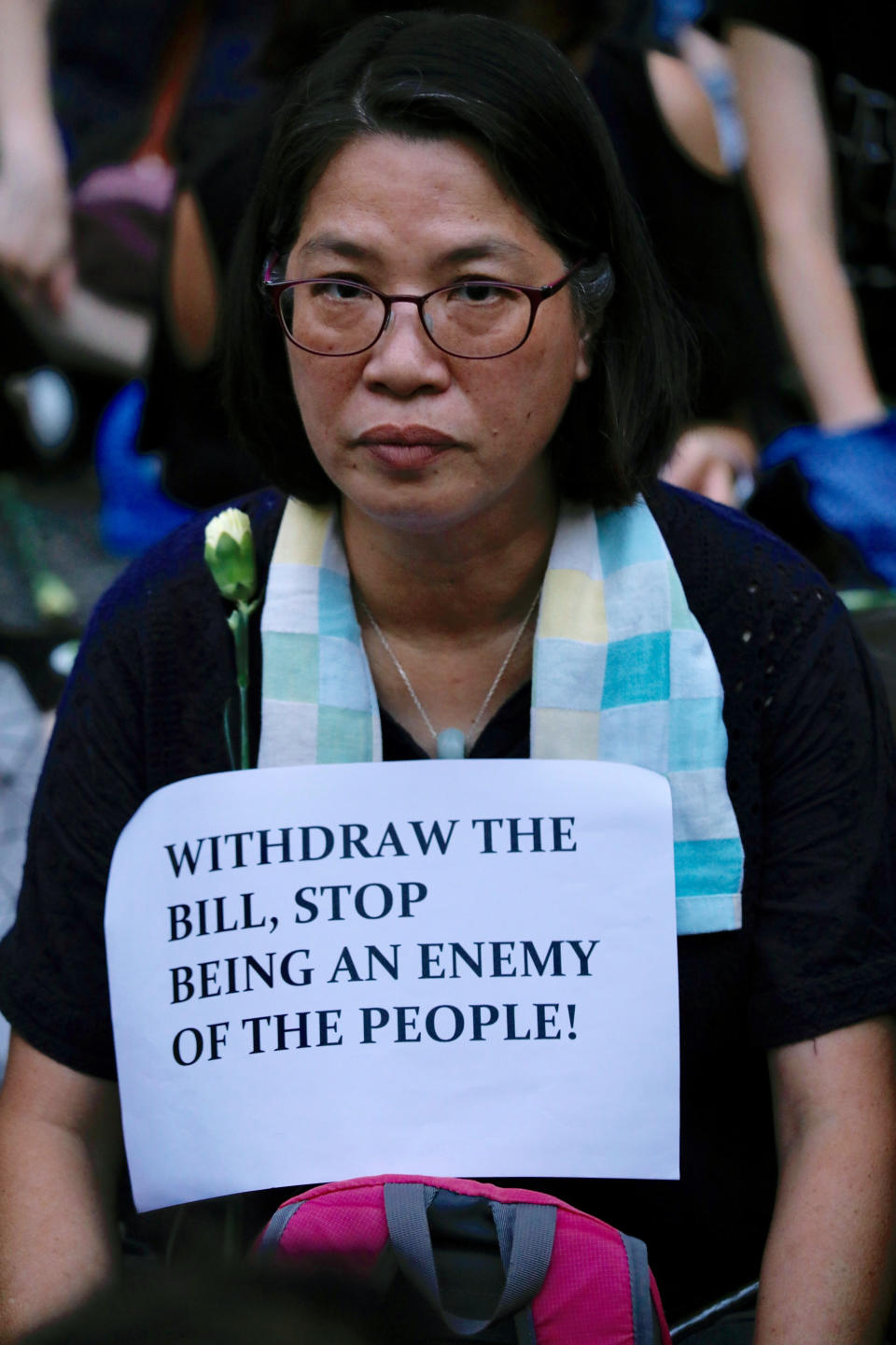 A woman joins hundreds of mothers protesting against the amendments to the extradition law after Wednesday's violent protest in Hong Kong on Friday, June 14, 2019. Calm appeared to have returned to Hong Kong after days of protests by students and human rights activists opposed to a bill that would allow suspects to be tried in mainland Chinese courts. (AP Photo/Vincent Yu)
