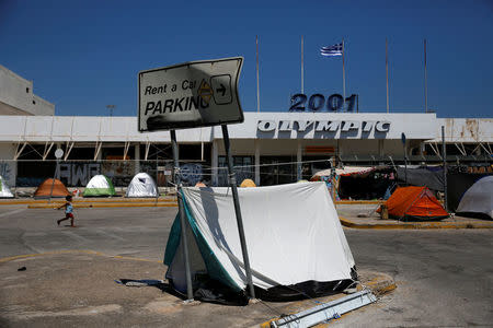 A child runs next to tents set at the premises of the disused Hellenikon airport, where refugees and migrants are temporarily housed, in Athens, Greece, July 13, 2016. Picture taken July 13, 2016. REUTERS/Alkis Konstantinidis