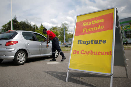 A security officer talks with a customer near a placard which reads "Out of Fuel" at a petrol station in Reze near Nantes, France, May 24, 2016. REUTERS/Stephane Mahe