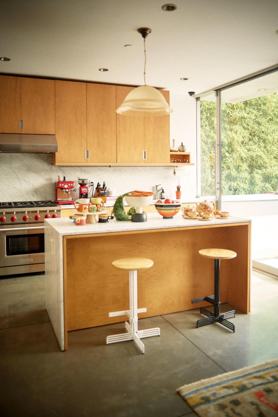 George continues to live a minimalist lifestyle, in a way. The clean lines of his wood and marble kitchen complement the lush landscape just beyond the glass doors.