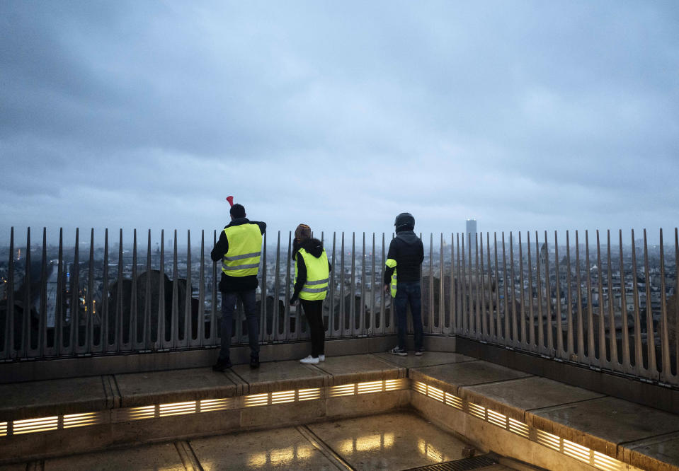 Demonstrators watch from the top of the Arc de Triomphe on the Champs-Elysees avenue during a demonstration Saturday, Dec.1, 2018 in Paris. Demonstrations against rising taxes turned into scenes of rioting in Paris city center as at least 65 people including 11 police officers have been injured in violent protests in the French capital. (AP Photo/Kamil Zihnioglu)