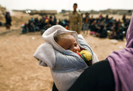 A displaced Iraqis woman who just fled her home, holds a baby as she arrive at special forces base as Iraqi forces battle with Islamic State militants in western Mosul, Iraq February 27, 2017. REUTERS/Zohra Bensemra