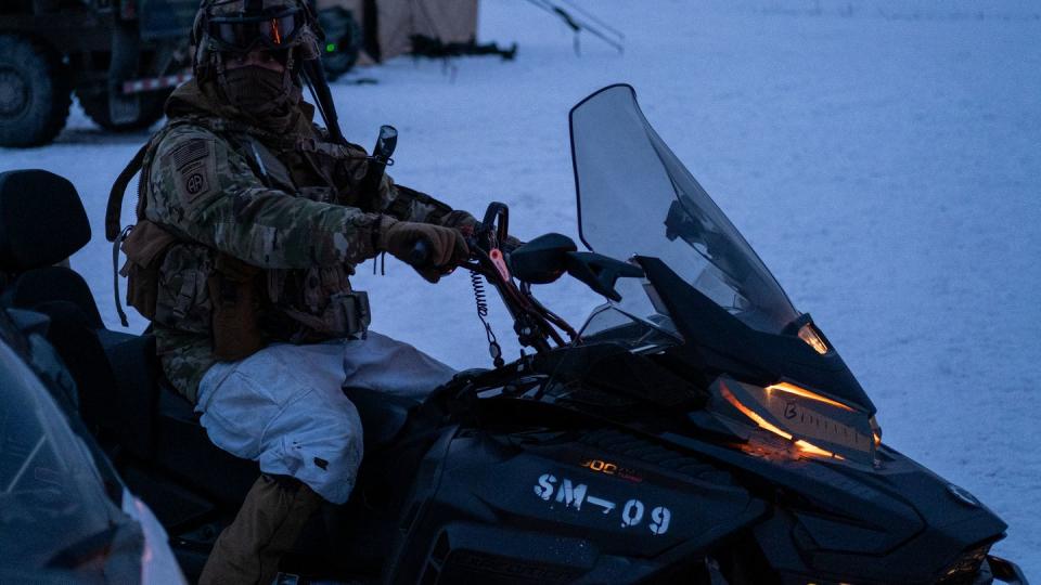 A soldier from 1-40th Cavalry, 2nd Infantry Brigade Combat Team, 11th Airborne Division prepares a snowmobile to load onto a CH-47 Chinook helicopter at the Yukon Training Area, Alaska on April 3, 2023. (Benjamin Wilson/Army)