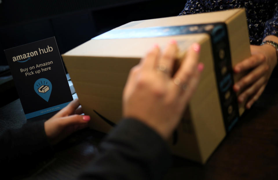 Employees demonstrate Amazon Counter, a click and collect service allowing customers to collect their Amazon parcels in-store at a Next store in London, Britain, May 14, 2019. REUTERS/Hannah McKay