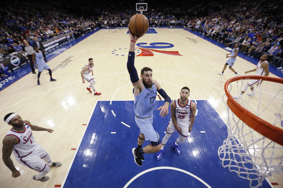 Memphis Grizzlies' Jonas Valanciunas (17) goes up for a dunk past Philadelphia 76ers' Ben Simmons (25) during the first half of an NBA basketball game Friday, Feb. 7, 2020, in Philadelphia. (AP Photo/Matt Slocum)