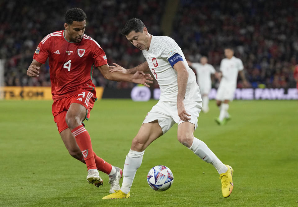 FILE - Wales' Ben Davies, left, challenges for the ball with Poland's Robert Lewandowski during the UEFA Nations League soccer match between Wales and Poland at the Cardiff City Stadium in Cardiff, Wales, Sunday, Sept. 25, 2022. (AP Photo/Frank Augstein, File)