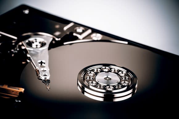 A hard drive with the casing opened up, in dramatic lighting.