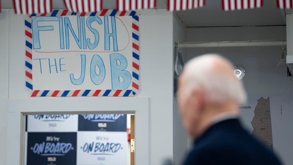 A poster reading "Finish the Job" hangs on the wall as Biden speaks during a visit to a campaign field office in Manchester, New Hampshire, on March 11, 2024. - Maansi Srivastava/The New York Times/Redux