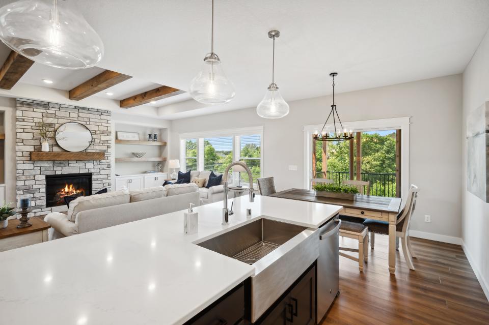 The gourmet kitchen touts an eight-foot center prep island with a farmhouse sink and quartz countertops.