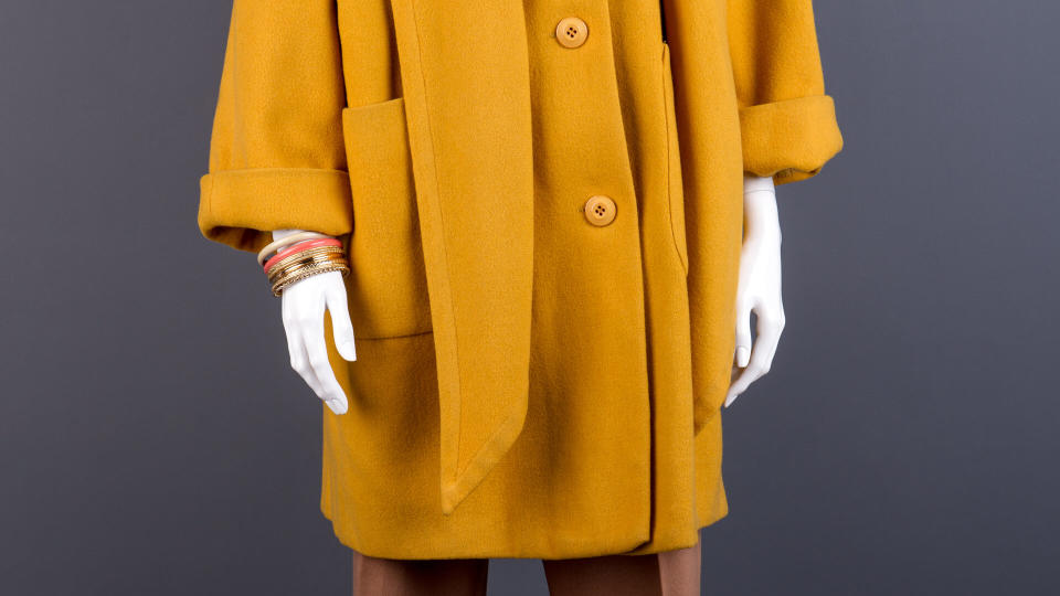 Female mannequin in yellow topcoat.