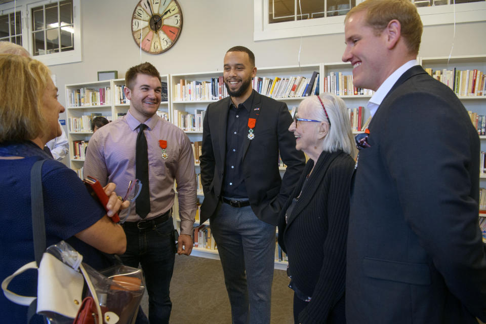 Alek Skarlatos, left, Anthony Sadler, Dorothy Eskel and her grandson Spencer Stone celebrate following a French Naturalization Ceremony for the three men in Sacramento, Calif., Thursday, Jan. 31, 2019. The three men were heralded as heroes when they subdued an armed terrorist on a train in France in 2015. Today they were granted French citizenship. (AP Photo/Randall Benton)