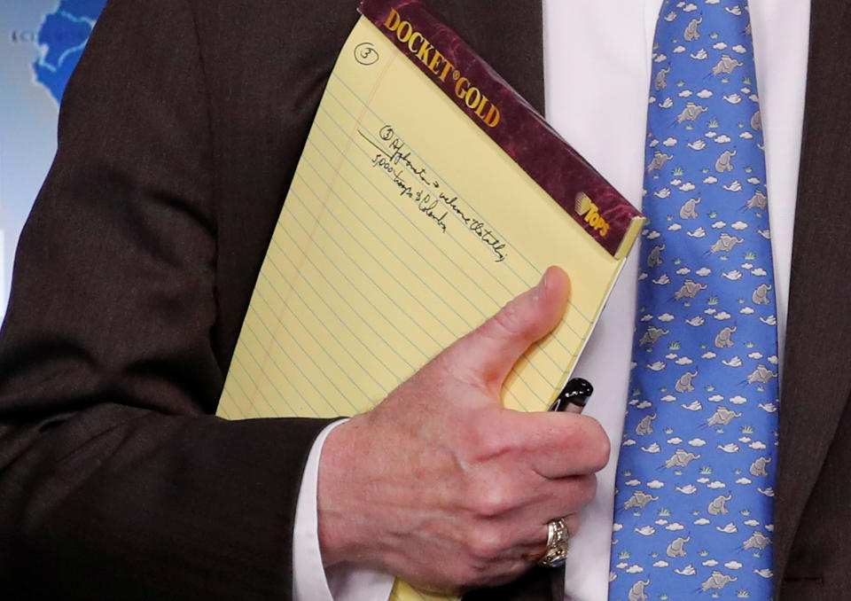 U.S. National Security Adviser John Bolton holds a writing pad with a written note that reads "5,000 troops to Colombia," while he waits to address reporters, as the Trump administration announces economic sanctions against Venezuela and the Venezuelan state owned oil company Petroleos de Venezuela (PdVSA) during a press briefing at the White House in Washington, U.S., January 28, 2019. REUTERS/Jim Young