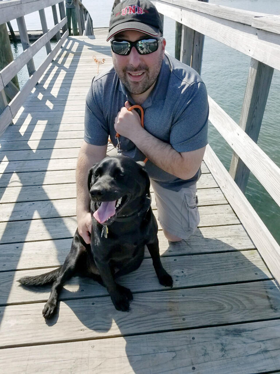 CORRECTS TO BELLOCCHIO, NOT BELLOCCIO - This August 2019 photo provided by Josh Bellocchio shows his brother, John, with his service dog, Seamus, in Lincoln Harbor, Maine. John, of New Jersey, has sued both former Cardinal Theodore McCarrick and the Holy See, alleging the prelate abused him in the 1990s when he was a teenager. (Josh Bellocchio via AP)