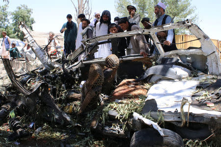 Afghan men inspect a car damaged in a suicide car bomb attack in Khost province, Afghanistan May 27, 2017. REUTERS/Stringer