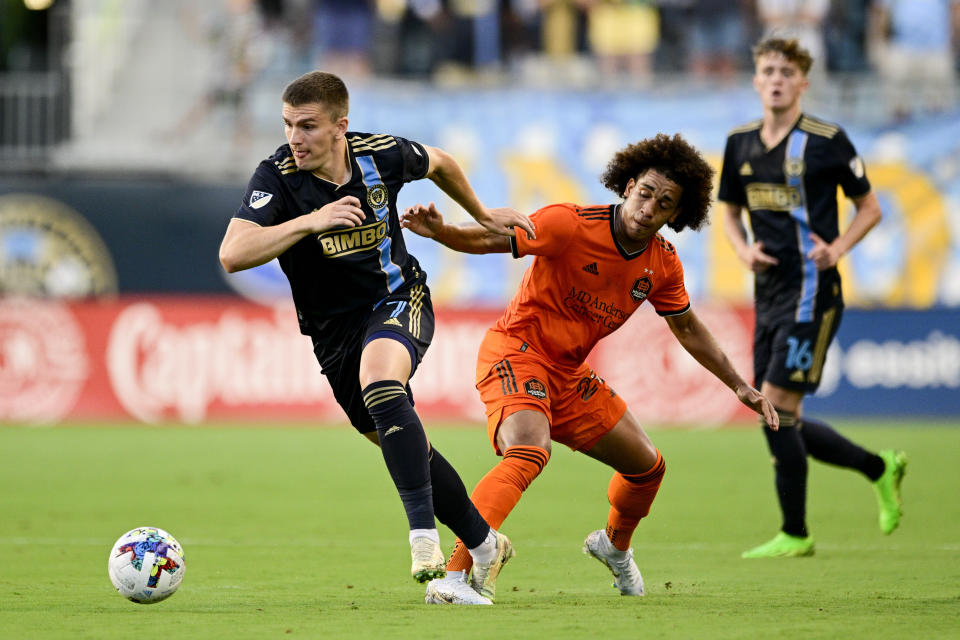 Philadelphia Union's Mikael Uhre, left, runs past the defense of Houston Dynamo's Adalberto Carrasquilla during the first half of an MLS soccer match Saturday, July 30, 2022, in Chester, Pa. (AP Photo/Derik Hamilton)
