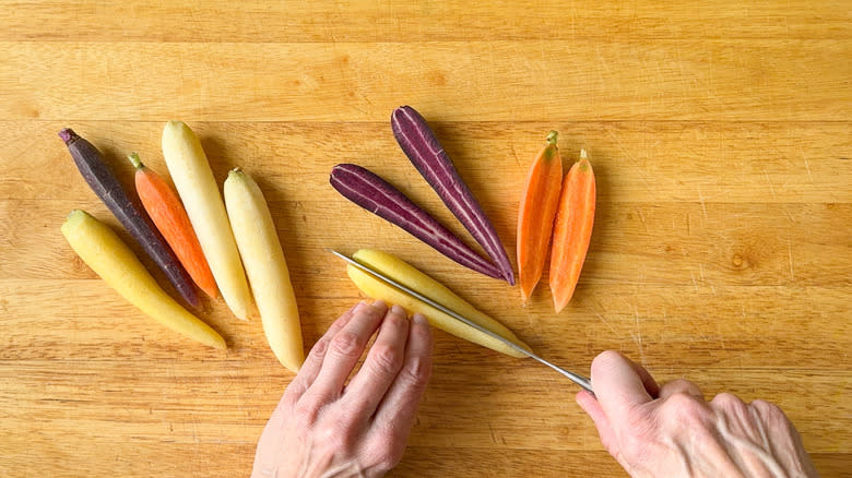 Cutting multi colored carrots on cutting board