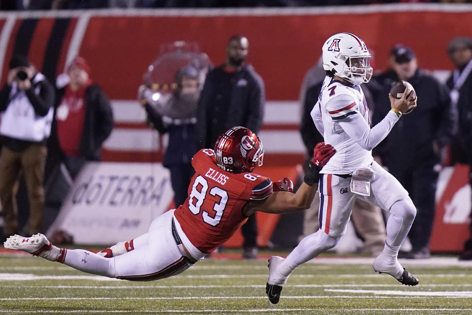 Utah defensive end Jonah Elliss (83) reaches for Arizona quarterback Jayden de Laura (7) as he carries the ball during the first half of an NCAA college football game Saturday, Nov. 5, 2022, in Salt Lake City. (AP Photo/Rick Bowmer)