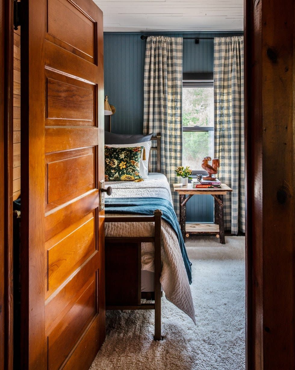 bedroom with deep blue beadboard and checked curtains