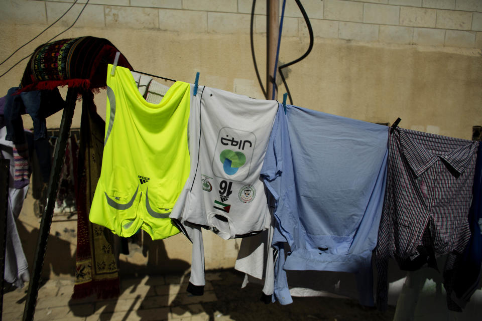 In this Tuesday, Feb. 11, 2014 photo, a Palestinian village's soccer team jersey is line dried, in the West Bank village of Wadi al-Nees. Palestinian farmer Yousef Abu Hammad sired enough boys for a soccer team and the current roster of the Wadi al-Nees team includes six of Abu Hammad's sons, three grandsons and five other close relatives. Wadi al-Nees heads the West Bank's 12-team “premier league,'' consistently defeating richer clubs and believe their strong family bonds are a secret to their success. (AP Photo/Dusan Vranic)