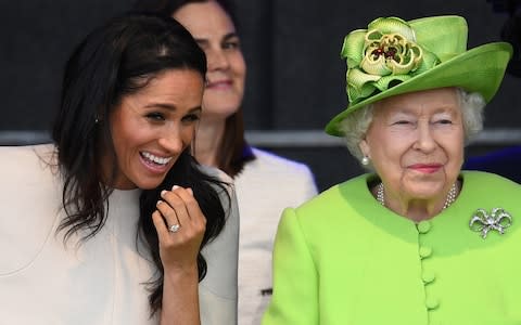 The Duchess of Sussex and Queen Elizabeth II laugh during their first engagement together in June, where they attended a ceremony to open the new Mersey Gateway bridge. - Credit: Jeff J Mitchell/Getty Images