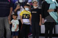 Afghan refugees wearing face masks to prevent the spread of the coronavirus, board an airplane bound for Portugal at the Eleftherios Venizelos International Airport in Athens, on Tuesday, Sept. 28, 2021. The 41 refugees from Afghanistan were relocated as part of a migrant reunification plan agreed between the two countries. (AP Photo/Thanassis Stavrakis)