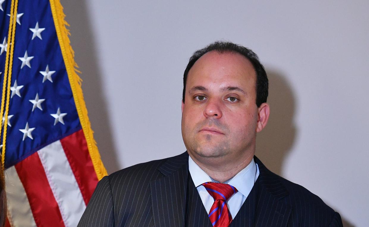 A mugshot of Boris Epshteyn against an American flag. 