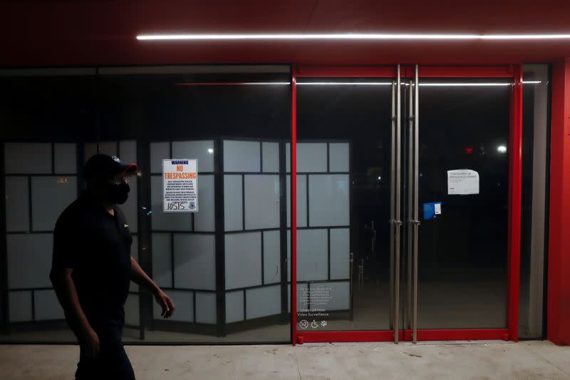 A man wearing a protective face mask walks by a closed business as the coronavirus disease (COVID-19) pandemic continues, in Sarasota