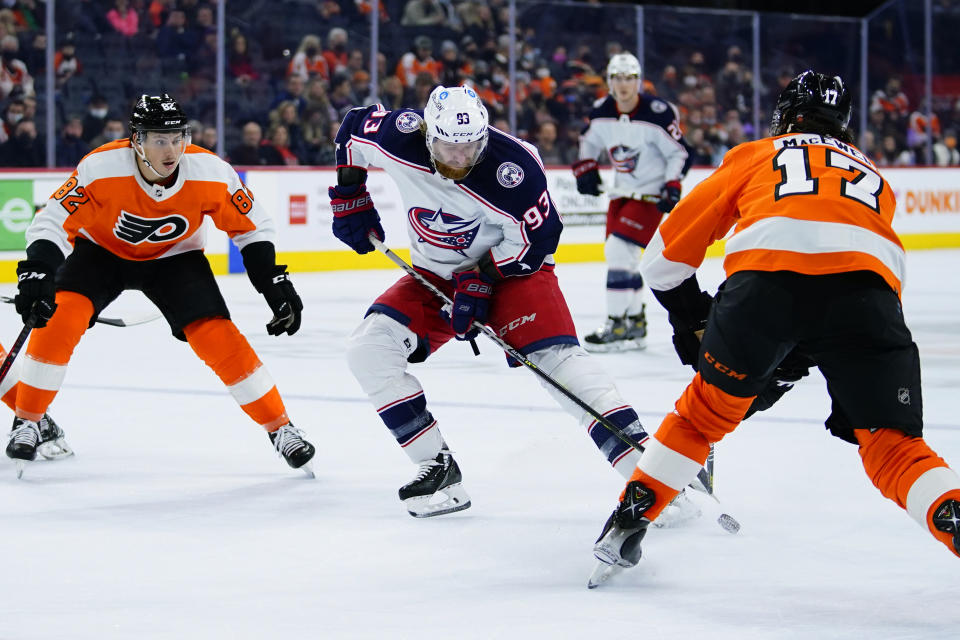 Columbus Blue Jackets' Jakub Voracek (93) tries to keep the puck away from Philadelphia Flyers' Zack MacEwen (17) and Connor Bunnaman (82) during the first period of an NHL hockey game, Thursday, Jan. 20, 2022, in Philadelphia. (AP Photo/Matt Slocum)