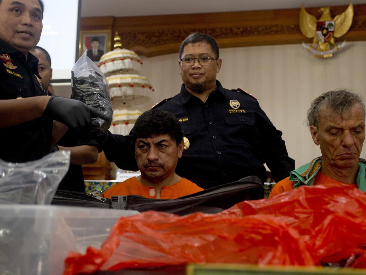 Indonesian customs officers display drug hauls in front of the Peruvian and the German suspects: AP