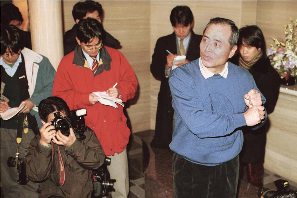 In this Dec. 11, 1998, photo, then Fukuoka Daiei Hawks manager Sadahara Oh, front right, answers to reporters' questions in front of his house in Fukuoka, southern Japan, following the Japanese baseball team's investigation report on suspicion of sign stealing. If you thought the use of technology to steal catchers' signs was only a problem for Major League Baseball and the Houston Astros, or something new. Japan went through a similar scandal just over 20 years ago. In a widely reported scandal in 1998, a camera in the Fukuoka Dome was discovered to be focused on the catcher. Officials of the Hawks - now the SoftBank Hawks - reportedly monitored the signs and relayed them by walkie-talkie to fans in the stands, who then used signals to batters to indicated the next pitch. (Kyodo News via AP)