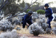 In this photo provided by the Japan Aerospace Exploration Agency (JAXA), members of JAXA retrieve a capsule dropped by Hayabusa2 in Woomera, southern Australia, Sunday, Dec. 6, 2020. A Japanese capsule carrying the first samples of asteroid subsurface shot across the night atmosphere early Sunday before successfully landing in the remote Australian Outback, completing a mission to provide clues to the origin of the solar system and life on Earth. (JAXA via AP)