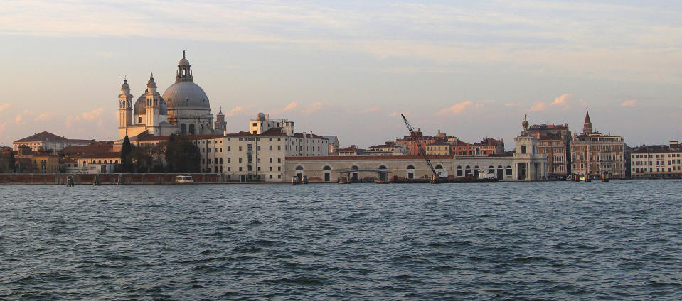 FILE - This Nov. 9, 2013 file photo shows the Basilica di Santa Maria della Salute (St. Mary of Health) at sunset as seen from the water to the south. The church, built after plague broke out in the 17th century, is a fixture of the city's skyline. Venice’s central place in the history of battling pandemics and pestilence will come into focus at this year’s Venice Film Festival, which opens Wednesday, Sept. 1, 2021, with the premiere of Pedro Almodovar’s in-competition “Madres Paralelas” (Parallel Mothers), which he developed during Spain’s 2020 coronavirus lockdown, one of the harshest in the West. (AP Photo/Michelle Locke)