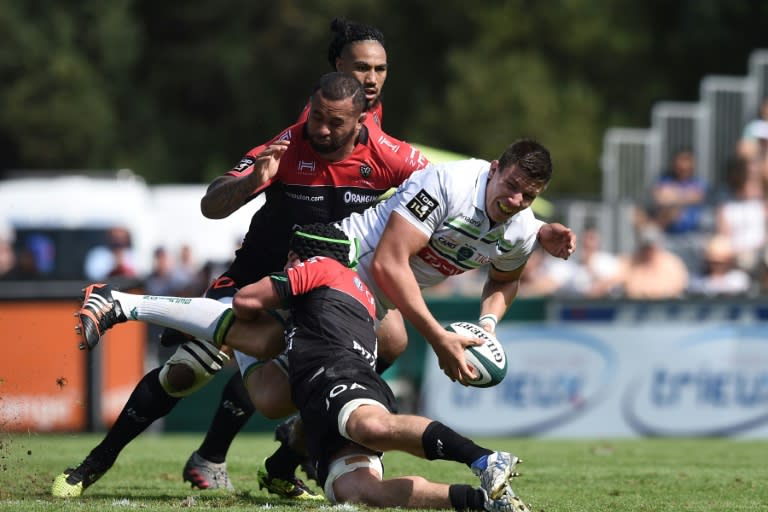 Pau's Irish flanker James Coughlan (centre) is tackled during the French Top 14 rugby union match between Pau and Toulon in Pau on August 27, 2016