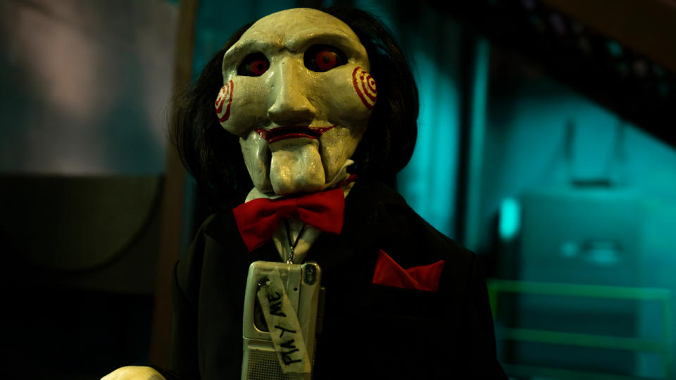 Billy the puppet, wearing a tape recorder around his neck, in Saw X.