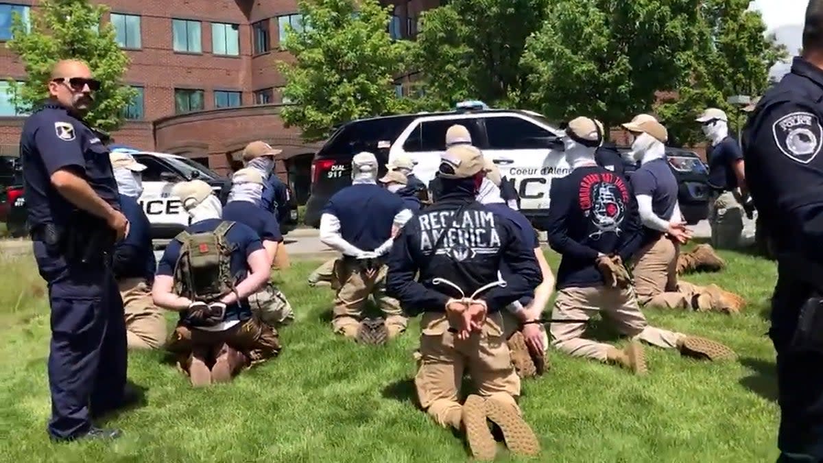Police officers guard a group of men, who police say are among 31 arrested for conspiracy to riot and are affiliated with white nationalist group Patriot Front, after they were found in the rear of a U Haul van in the vicinity of a North Idaho Pride Alliance LGBT+ event in Coeur d’Alene, Idaho (North Country Off Grid/Youtube/via Reuters)