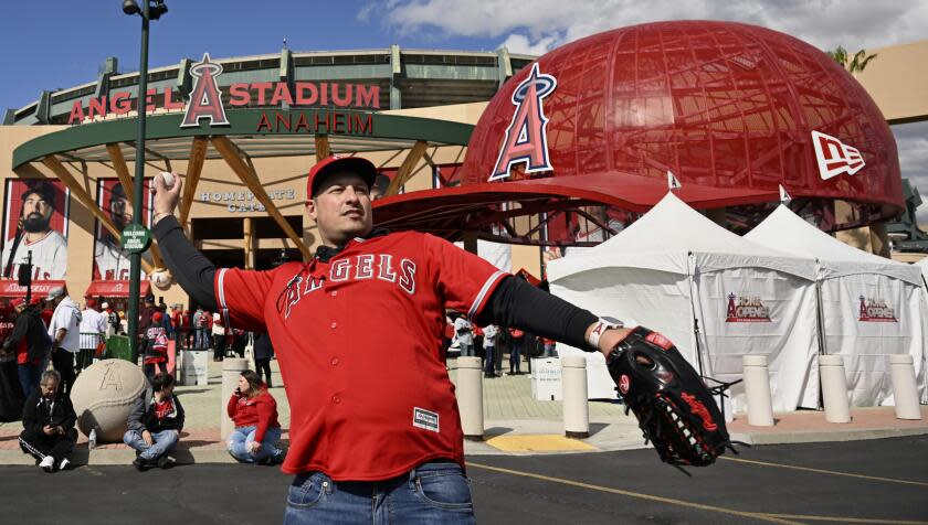 Fan Sam Sepanji throws a ball in front of Angel Stadium before the team's baseball game.