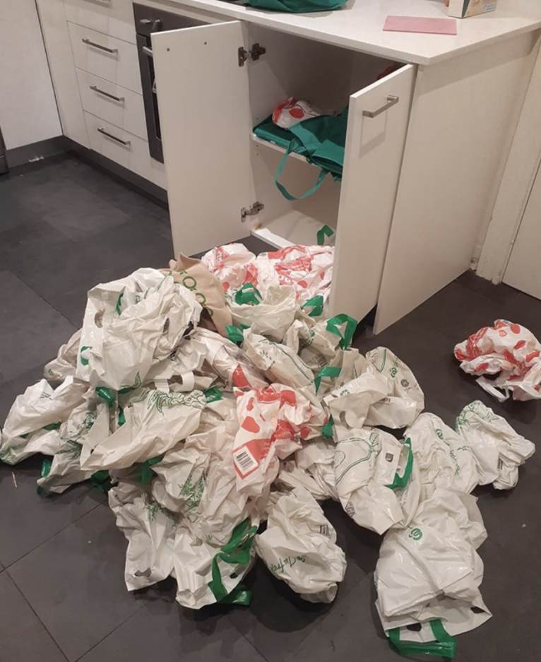 Reusable bags from Coles and Woolworths spilling out of cupboard as cockroach pest controller warns people not to shove them under the sink.