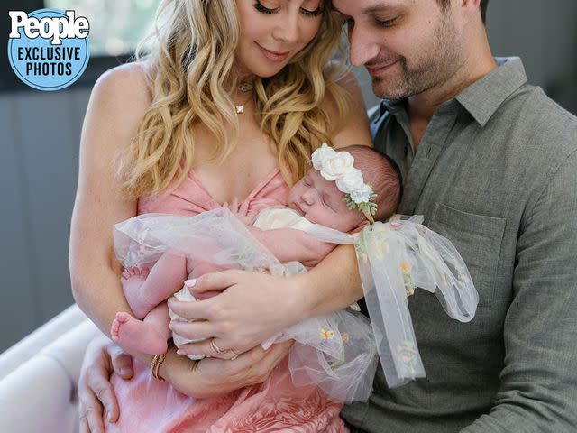 <p>Jenny Quicksall Photography</p> Tara Lipinski and Todd Kapostasy with their baby Georgie.