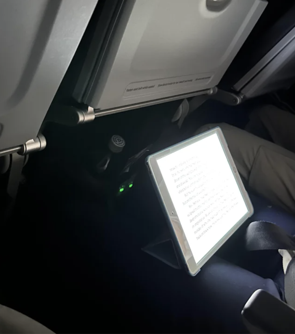 a person's bright iPad on a plane