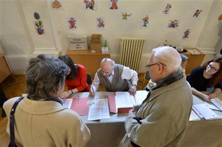 Members of an election committee prepare ballots for voters at a polling station during the first round presidential elections in Bratislava March 15, 2014. REUTERS/Radovan Stoklasa