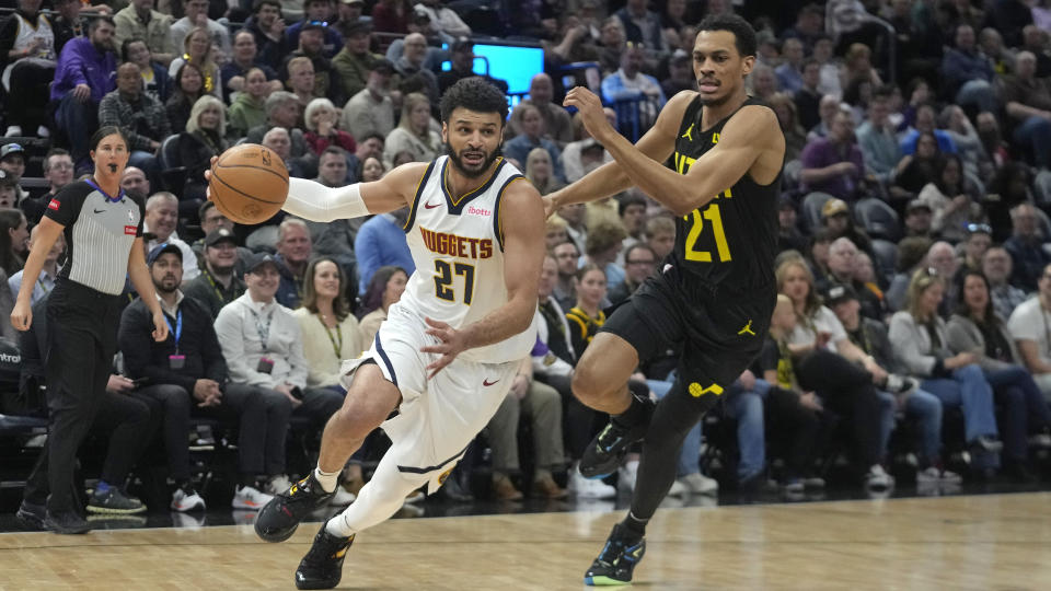 Denver Nuggets guard Jamal Murray (27) drives as Utah Jazz Darius Bazley (21) defends during in the first half of an NBA basketball game Tuesday, April 9, 2024, in Salt Lake City. . (AP Photo/Rick Bowmer)